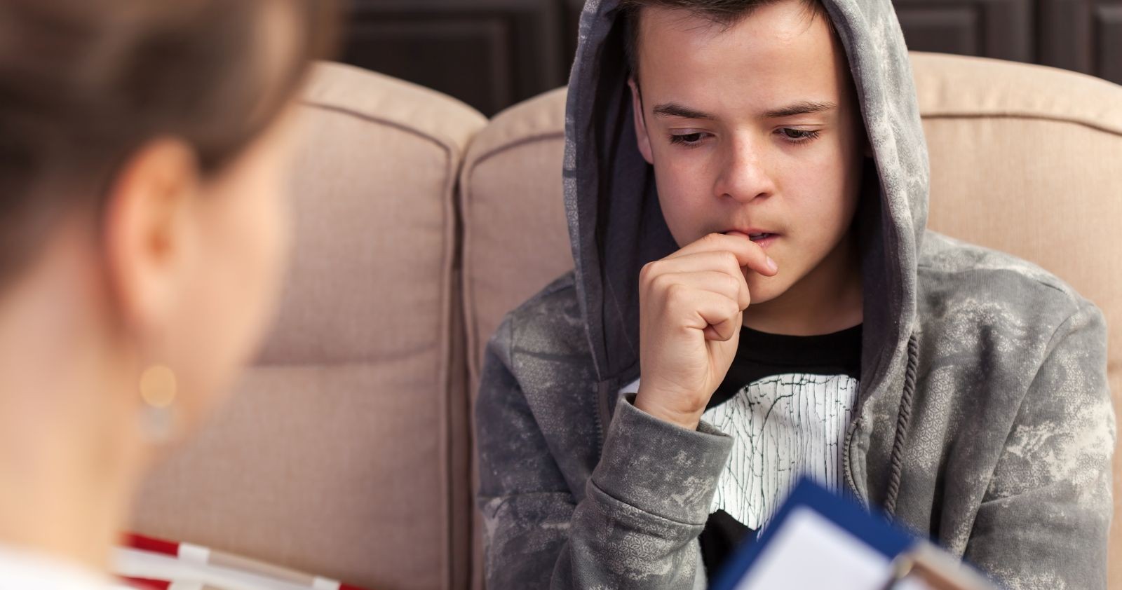 Ein Bursche sitzt bei einem Gespräch.