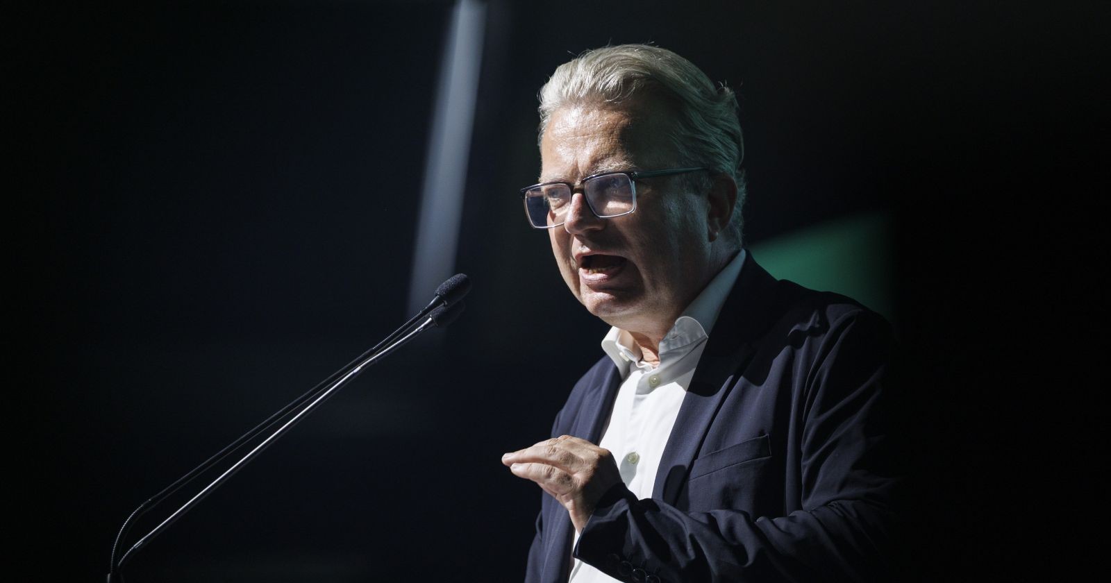 Christopher Drexler spricht gestikulierend in ein Mikrofon bei einer Veranstaltung.