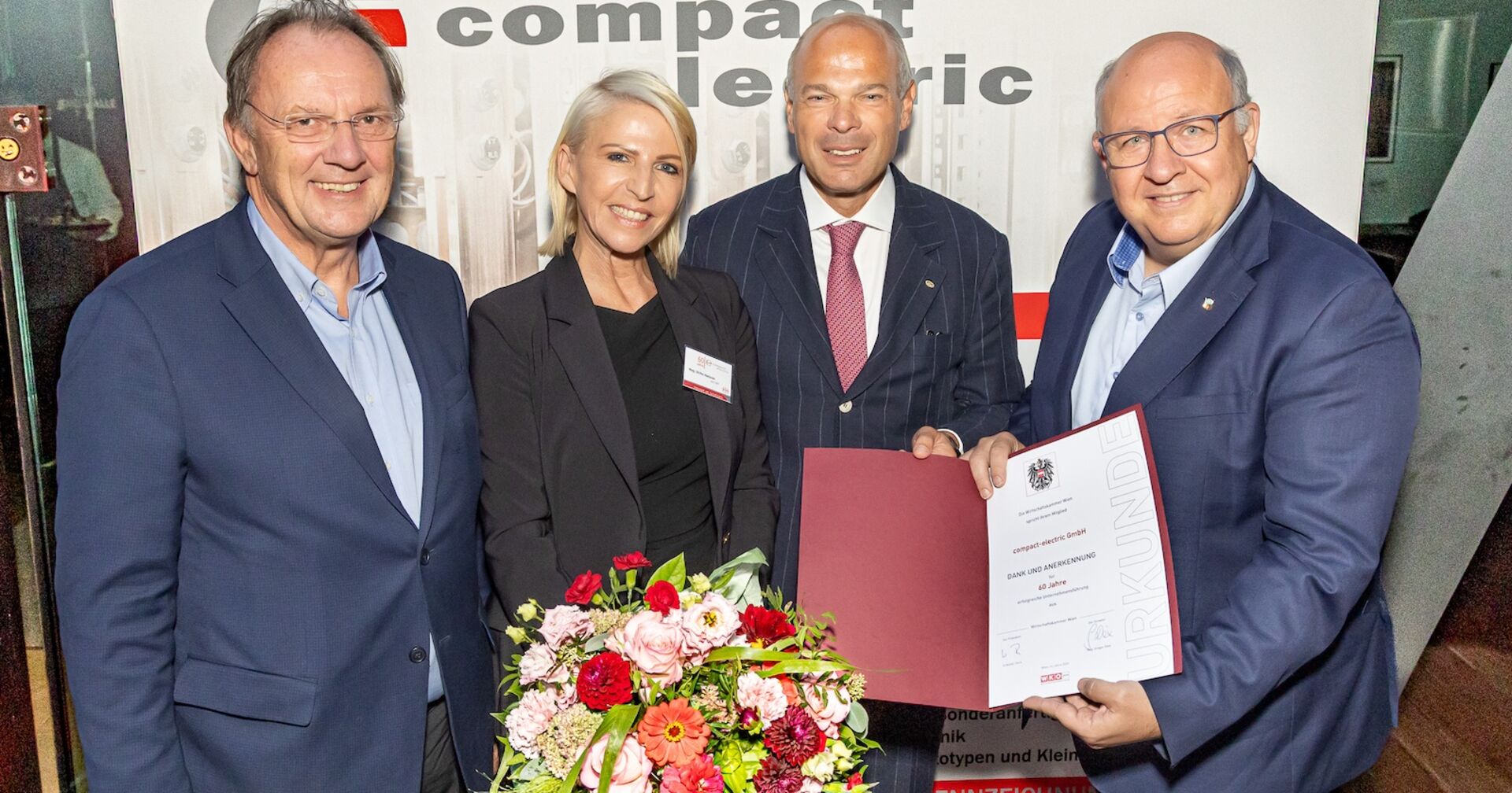 Gratulanten mit Blumen und Urkunde