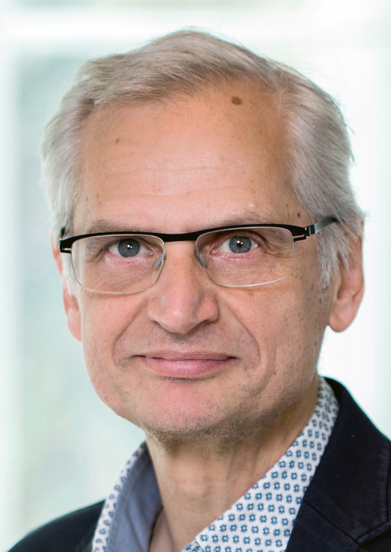 Gerhard Klösch mit grauen Haaren, Hemd und Sakko und Brille