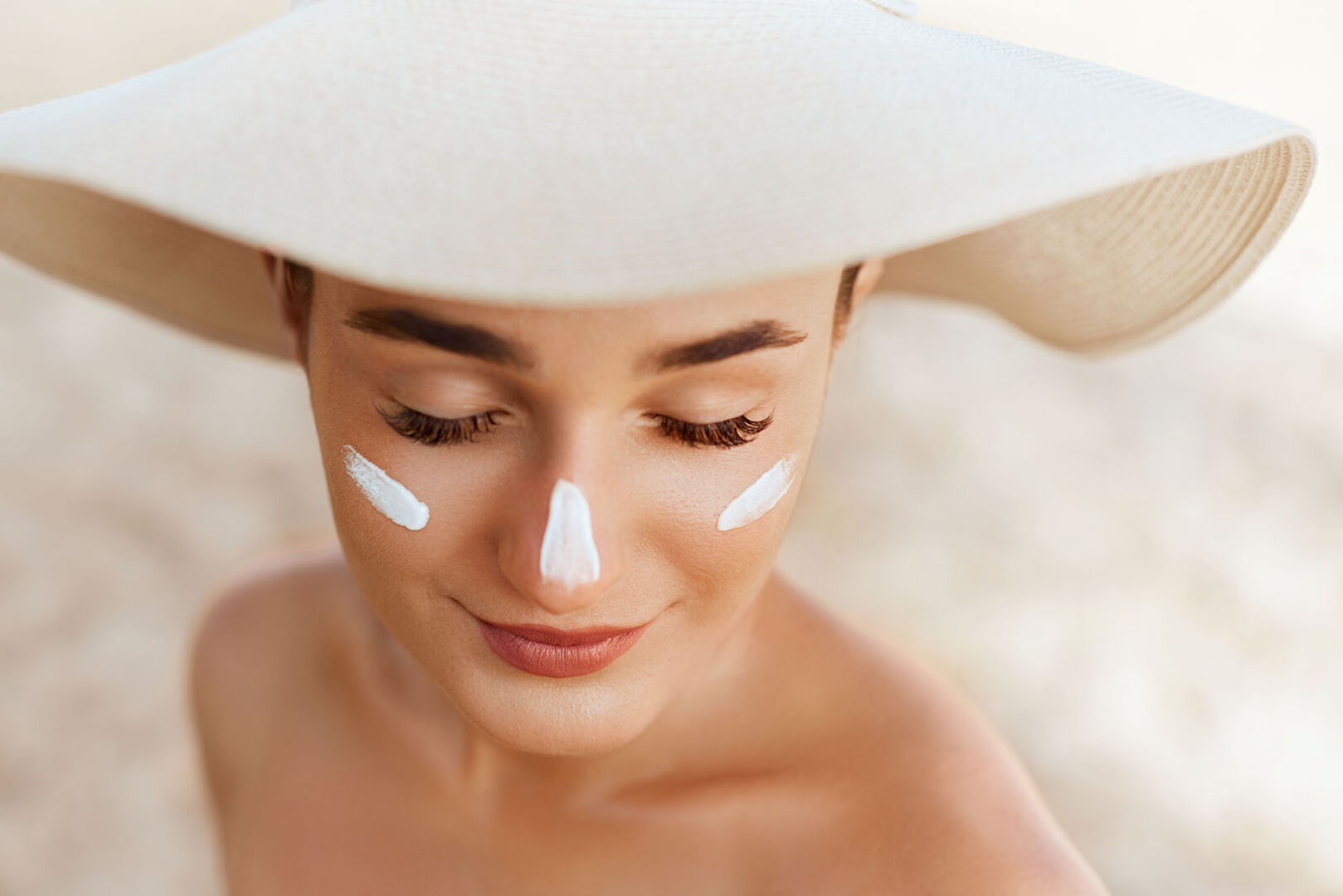 Frau trägt Sonnencreme im Gesicht auf | Credit: iStock.com/verona_S