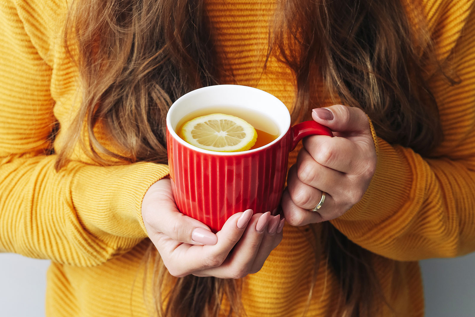 Frau hält Tasse in der Hand | Credit: iStock.com/szakalikus