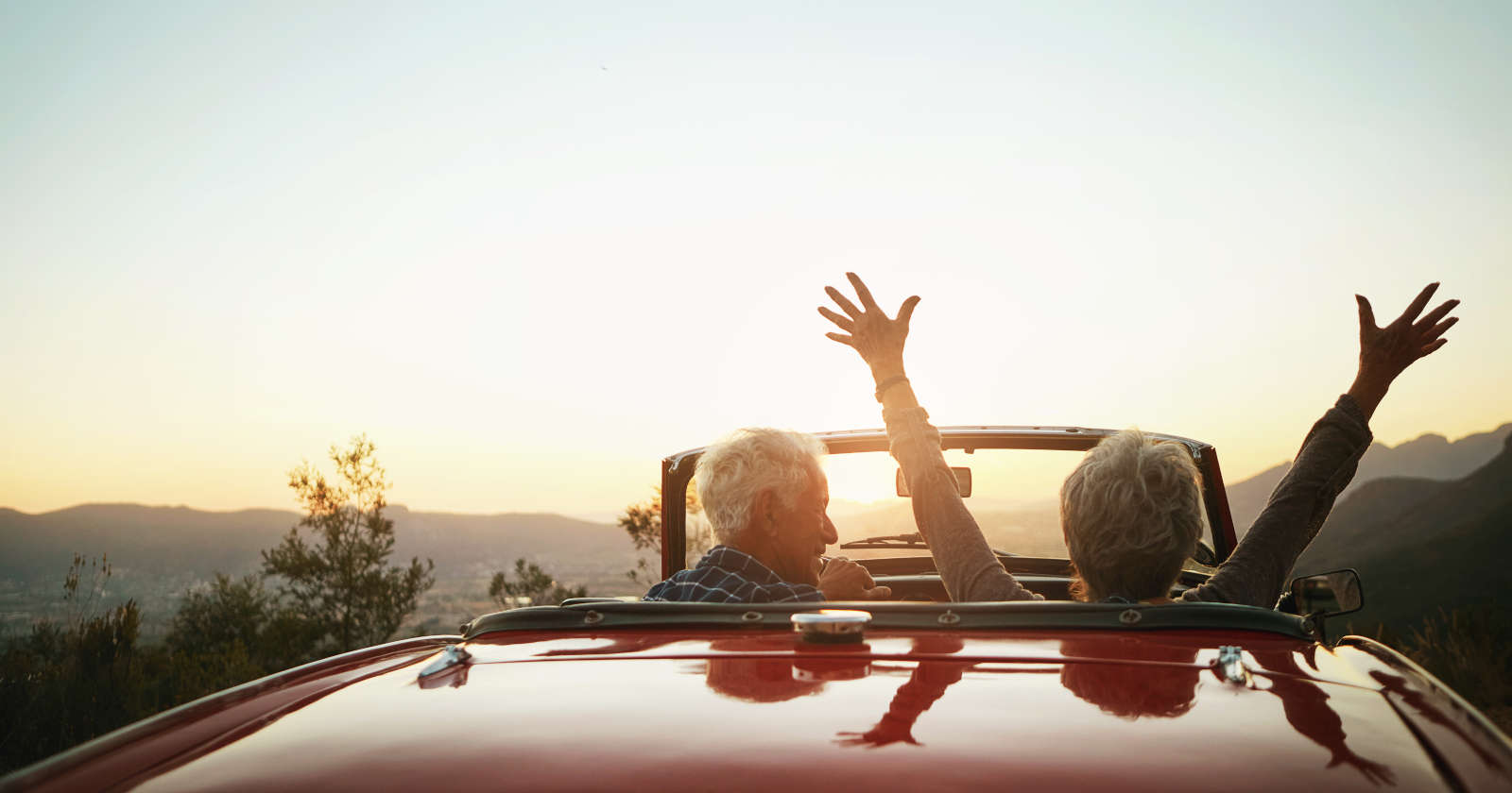 Zwei ältere Menschen sitzen in einem Cabrio