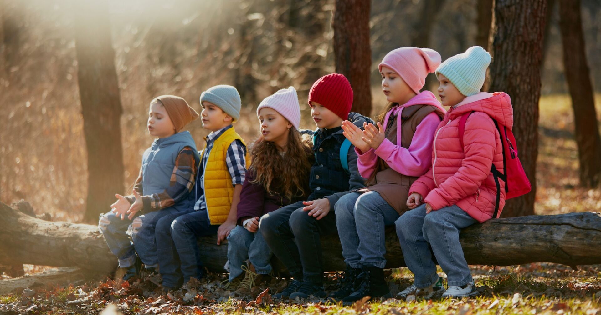 Kindergruppe sitzt im Wald auf