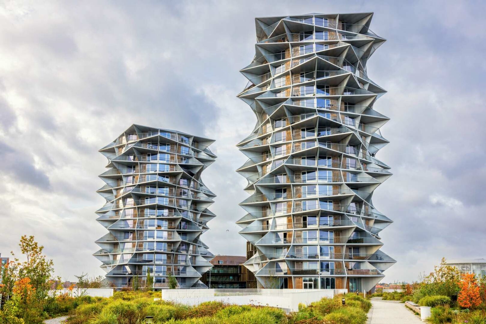 Zwei moderne Wohntürme mit verdrehten Etagen und spitzen Balkonen – die Kaktus Towers in Vesterbro, Kopenhagen, entworfen von der Bjarke Ingels Group.