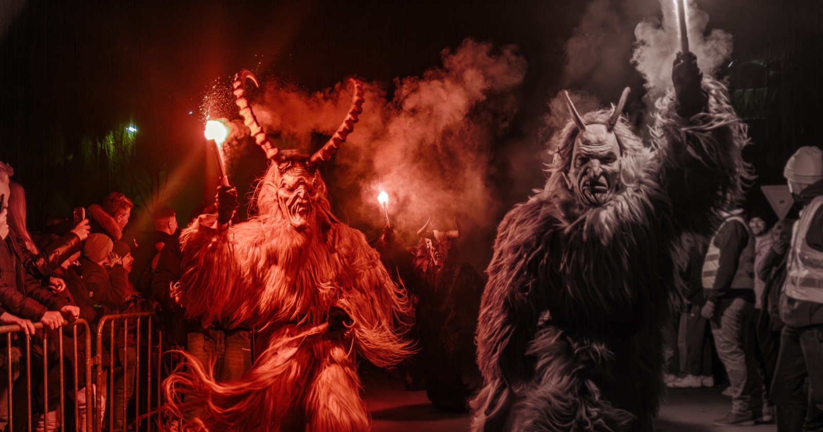 Zwei Krampusse laufen am Publikum vorbei.