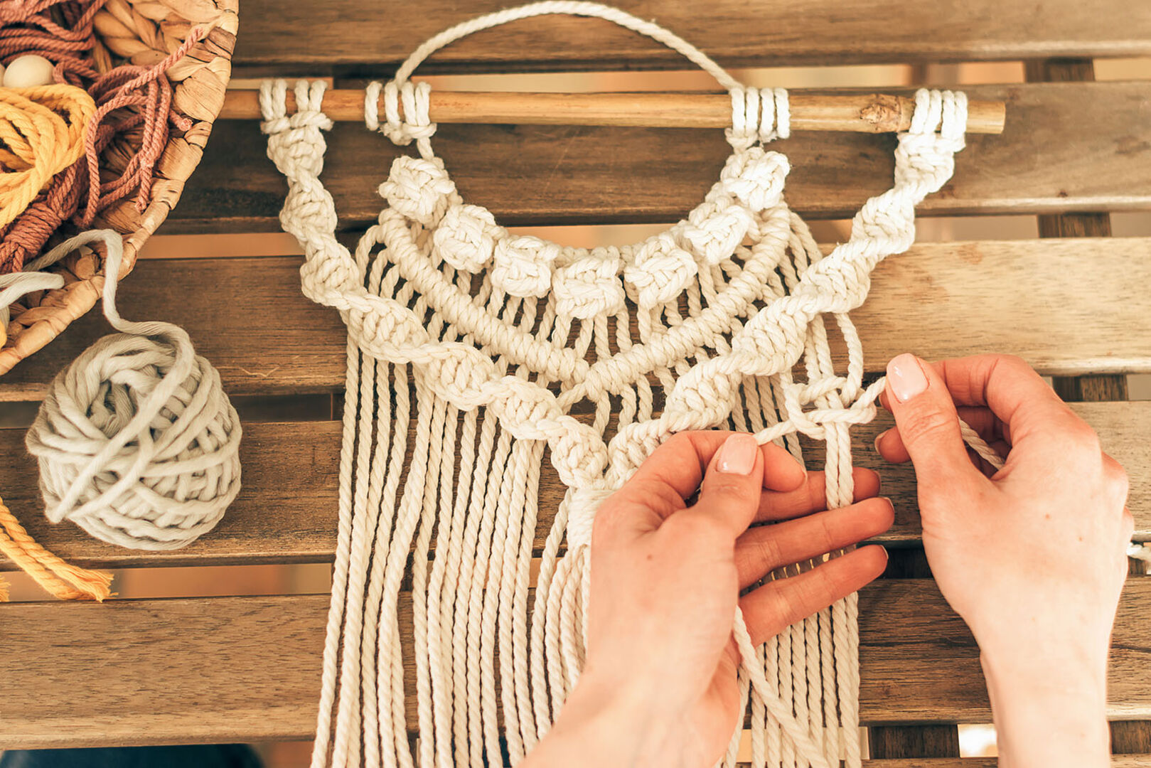 Frau knüpft Makramee-Wandteppich | Credit: iStock.com/Tatiana Buzmakova