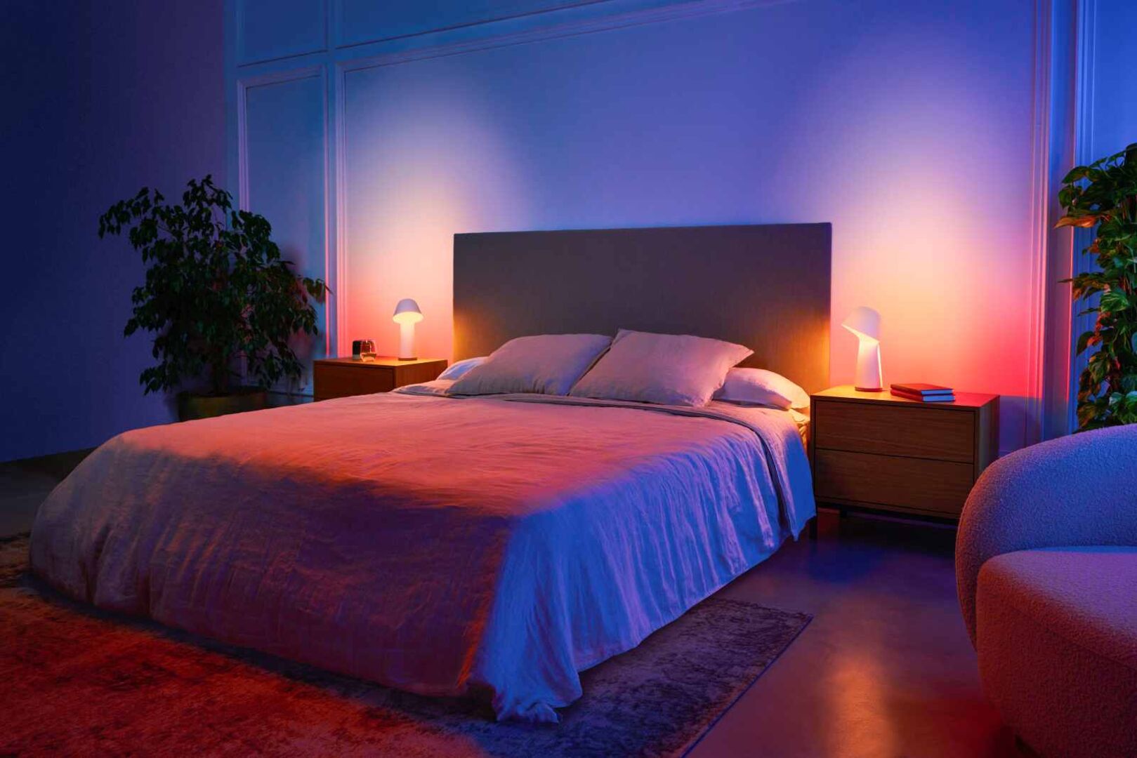 Modernes Schlafzimmer mit stimmungsvollem Licht: Auf den Nachtkästchen leuchten zwei Philips Hue Twilight Nachttischleuchten von Signify, smarte Lampen, die sich per App, Sprache oder Taste steuern und an den Schlafrhythmus anpassen lassen.