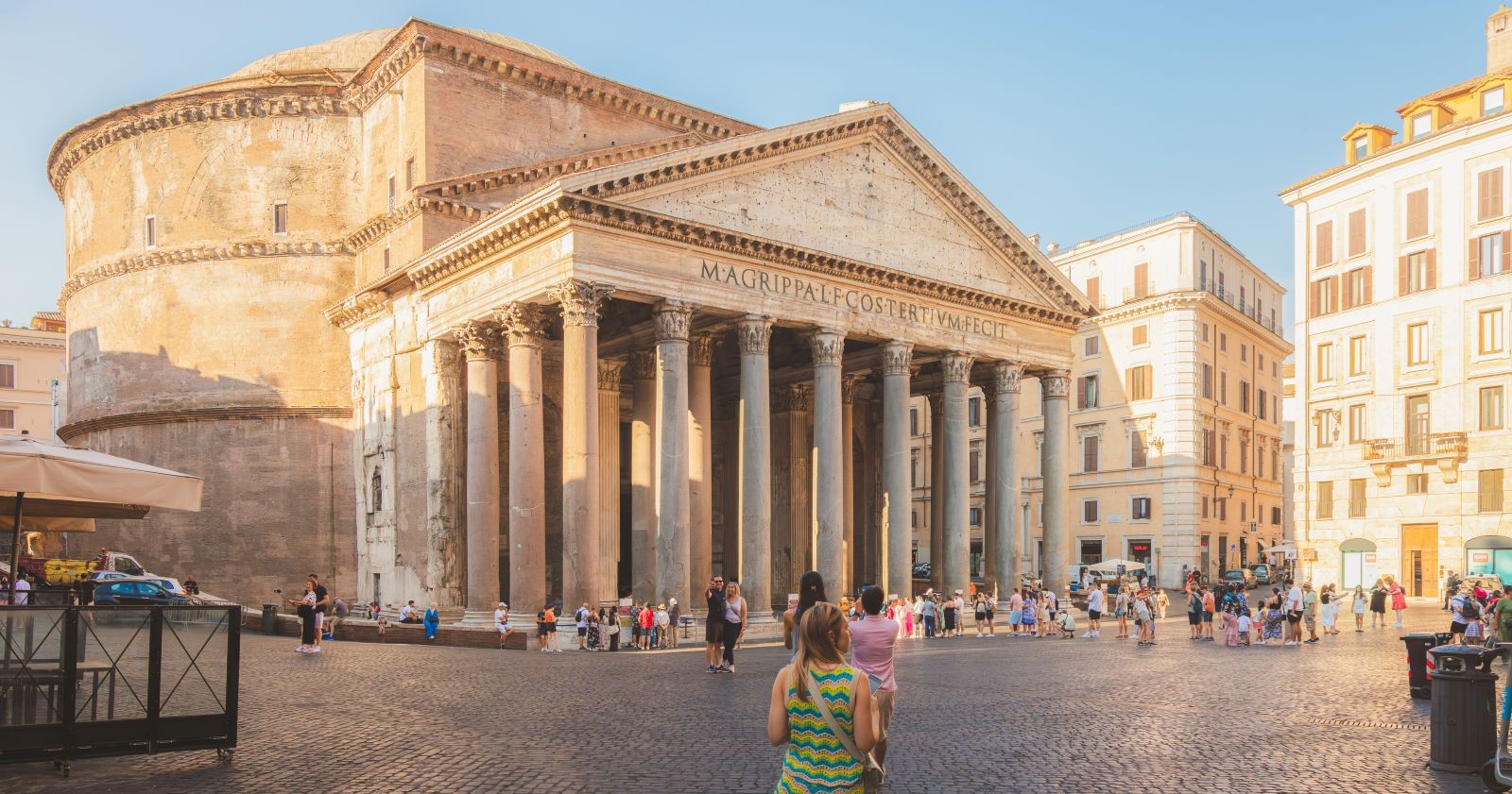 Blick auf das Pantheon in Rom mit Touristen auf dem Vorplatz bei Sonnenlicht.