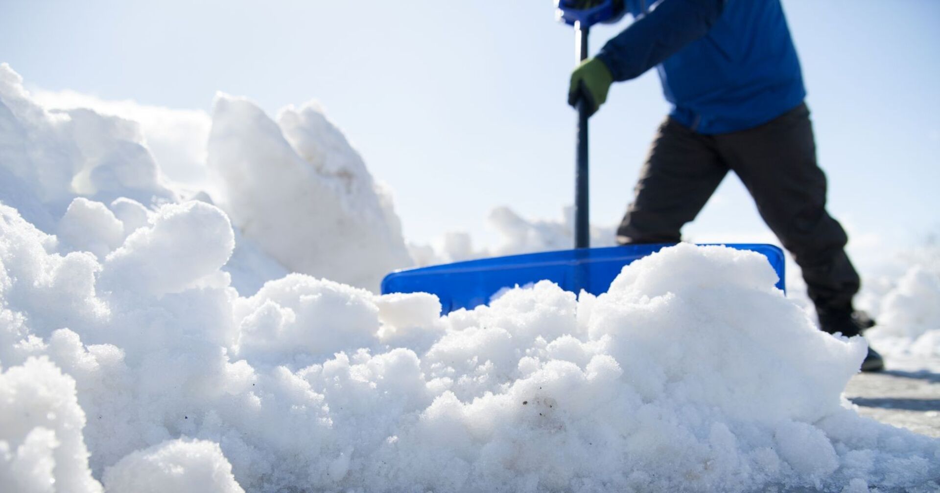Schwere Schneeräumung mit einem Schneedumper an einem sonnigen Tag