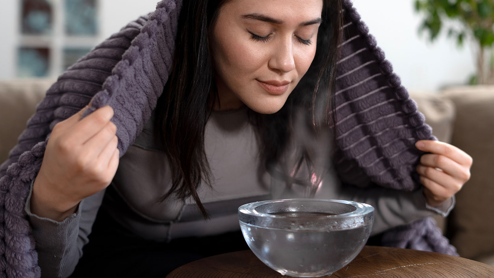 Frau inhaliert bei Halsschmerzen | Credit: iStock.com/izzetugutmen