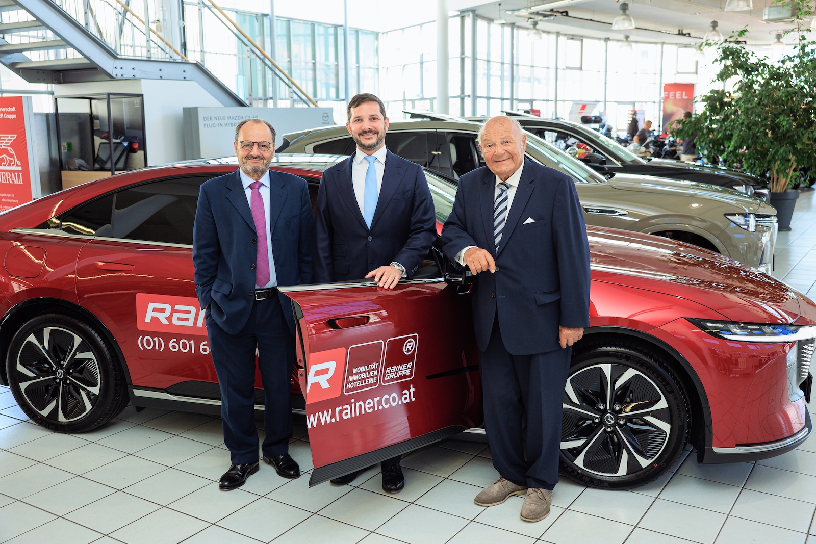 Gruppenbild der männlichen Familienangehörigen vor rotem KFZ