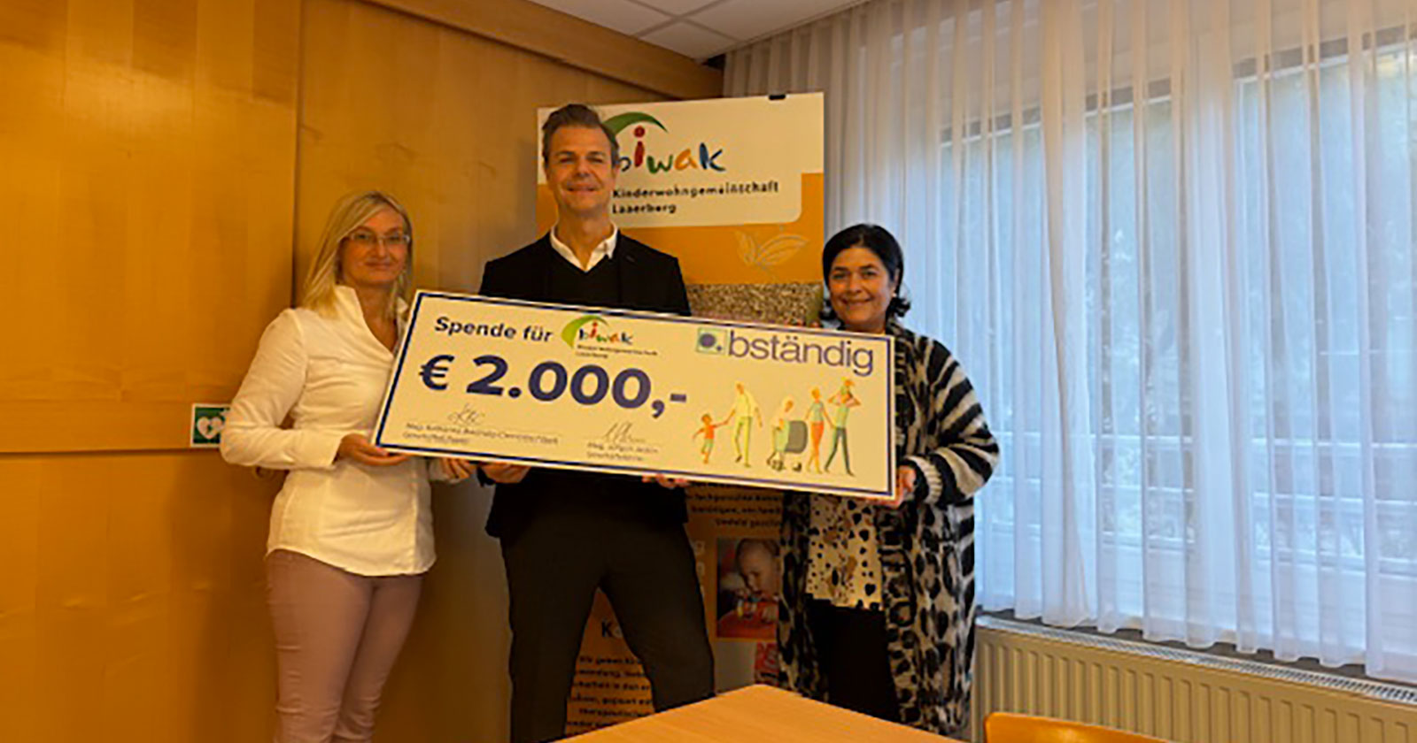 Drei Personen halten gemeinsam einen vergrößerten Spendenscheck in der Hand | Credit: bständig