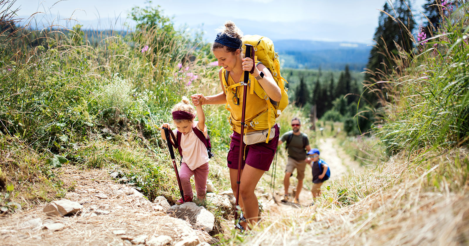 Junges Elternpaar beim Wandern mit seinen Kindern | Credit: iStock.com/Halfpoint