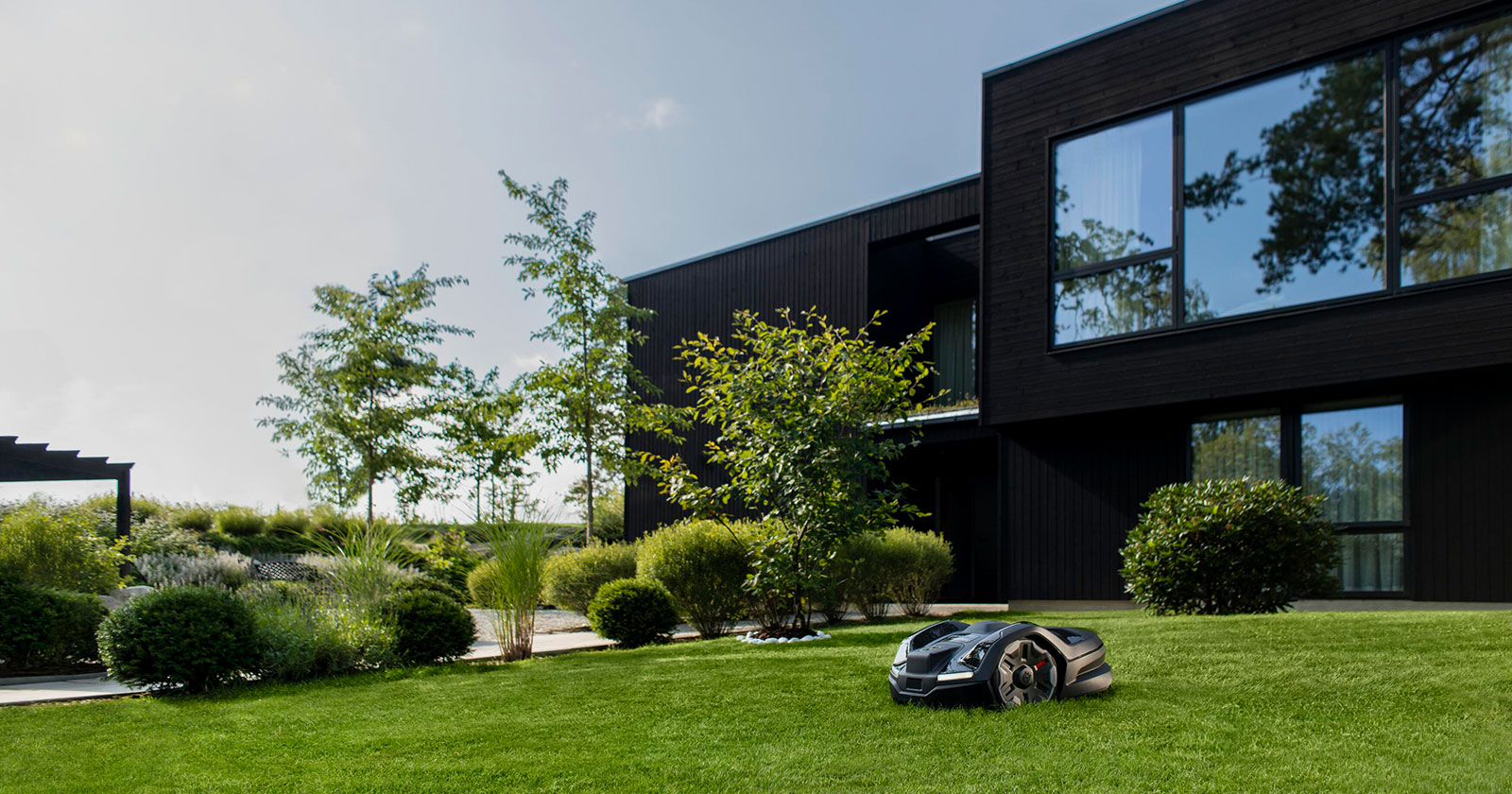 Mähroboter im Garten eines modernen Wohnhauses | Credit: Husqvarna