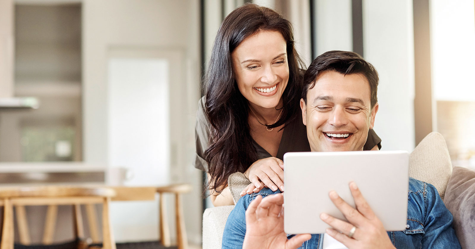 Paar liest gemeinsam Meldungen am Tablet | Credit: iStock.com/gradyreese