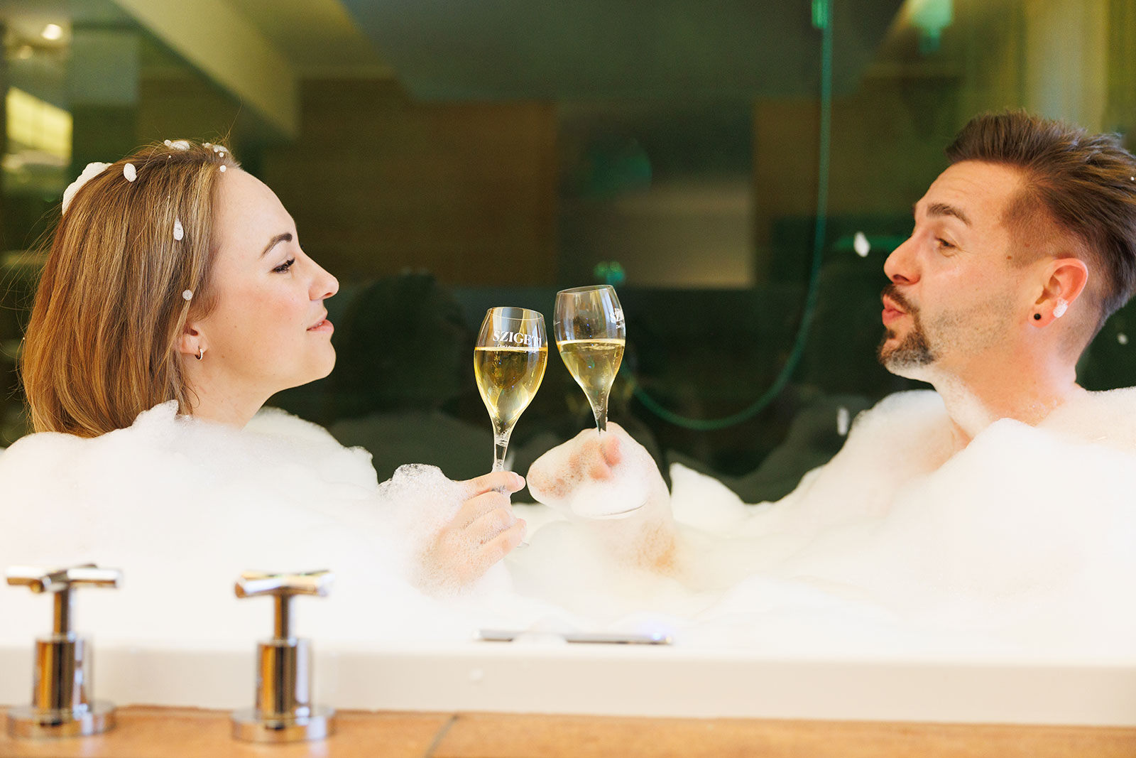 Junges Pärchen mit Sektgläsern in der Hand im Schaumbad | Credit: Spa Resort Styria