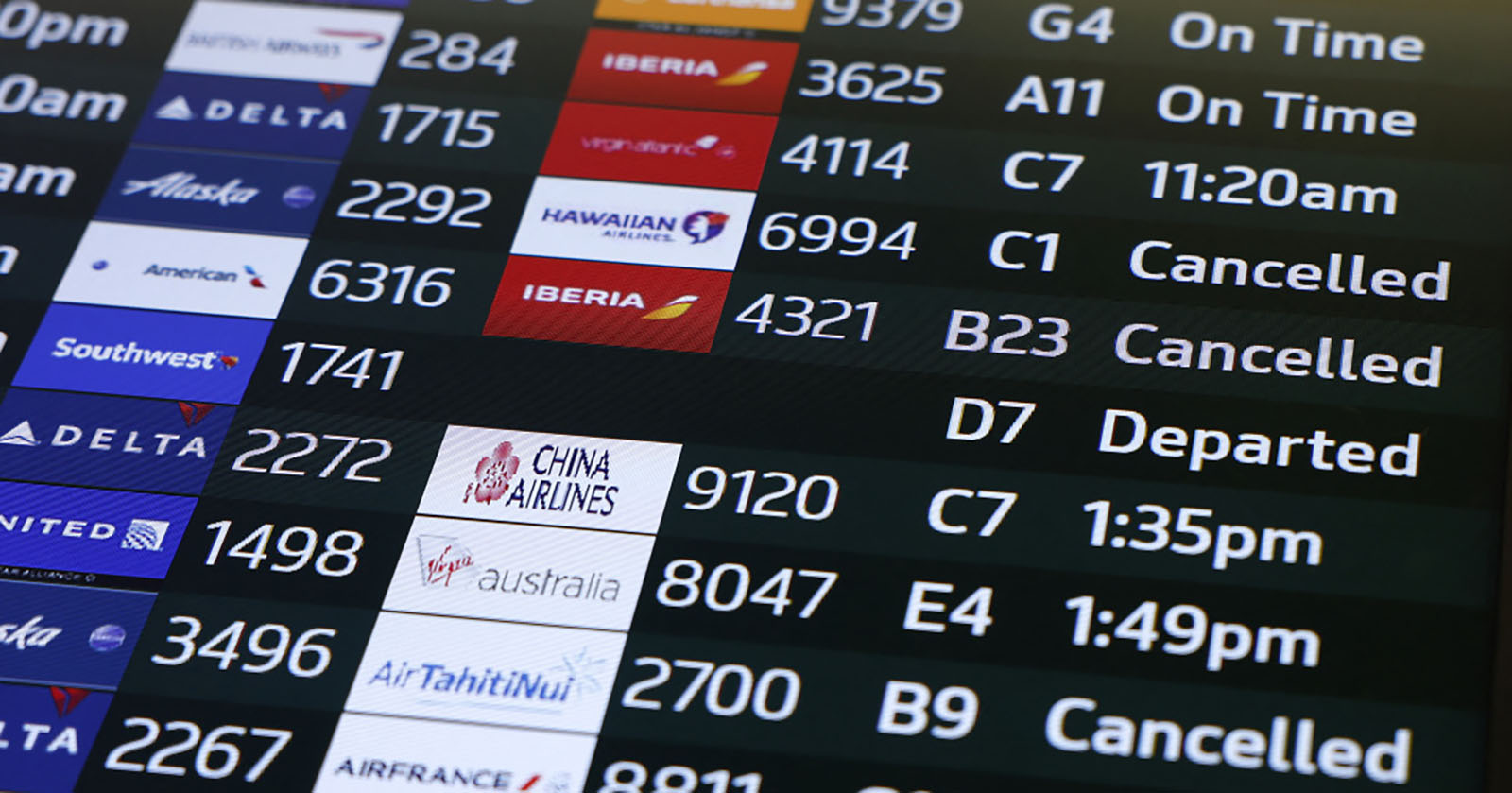 Anzeigetafel eines Flughafens, die eine Reihe von verspäteten oder ausgefallenen Flügen zeigt