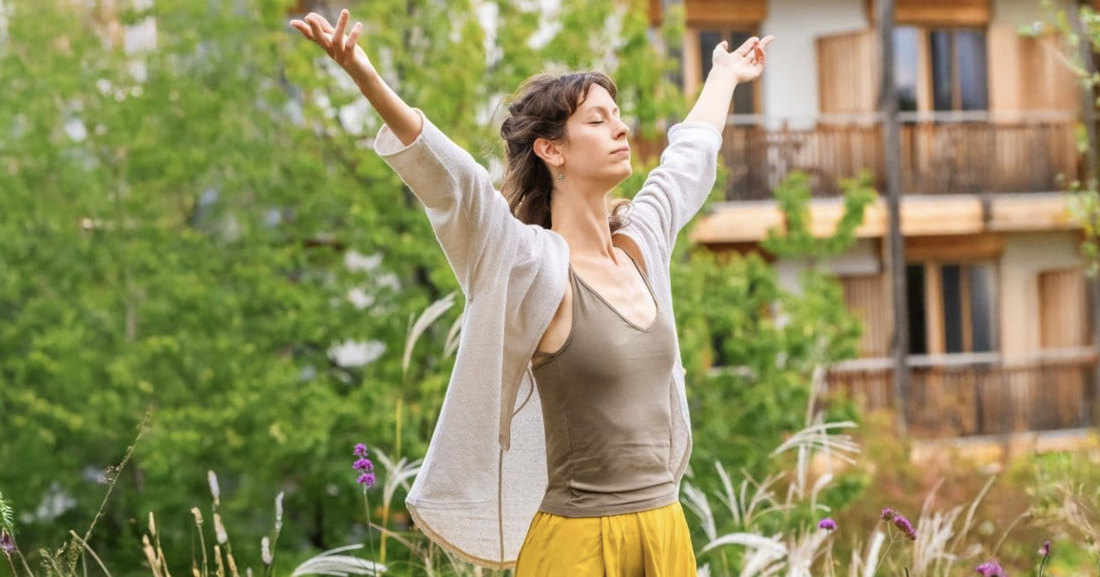 Frau mit geschlossenen Augen und gehobenen Armen outdoor