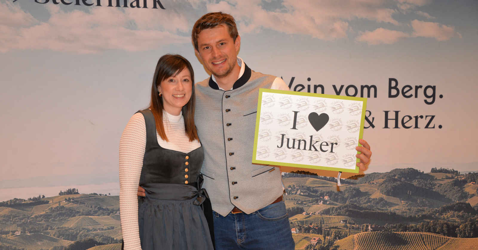 Ein Mann und eine Frau halten ein Schild hoch und lächeln