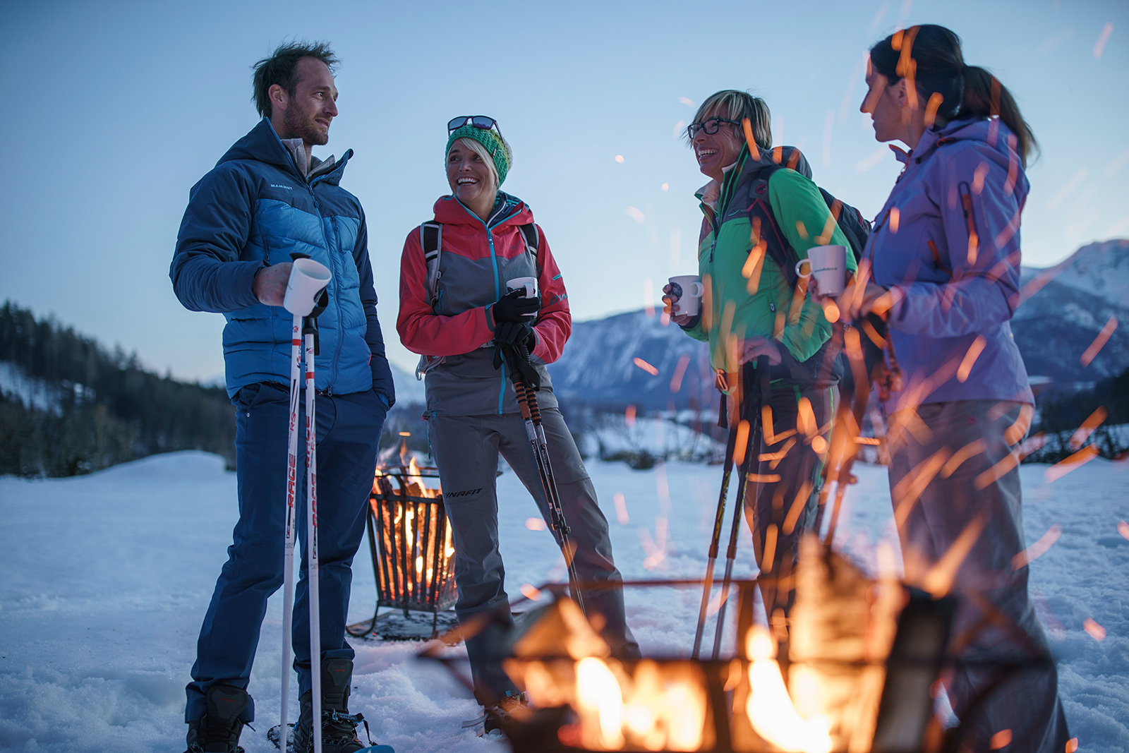 Eine Gruppe sitzt vor einem Feuer im Schnee | Credit: Oberösterreich Tourismus GmbH/Robert Maybach