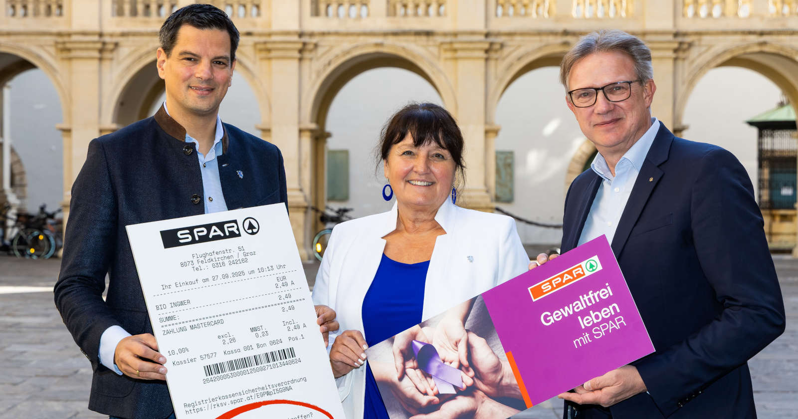 Zwei Männer und eine Frau blicken in die Kamera