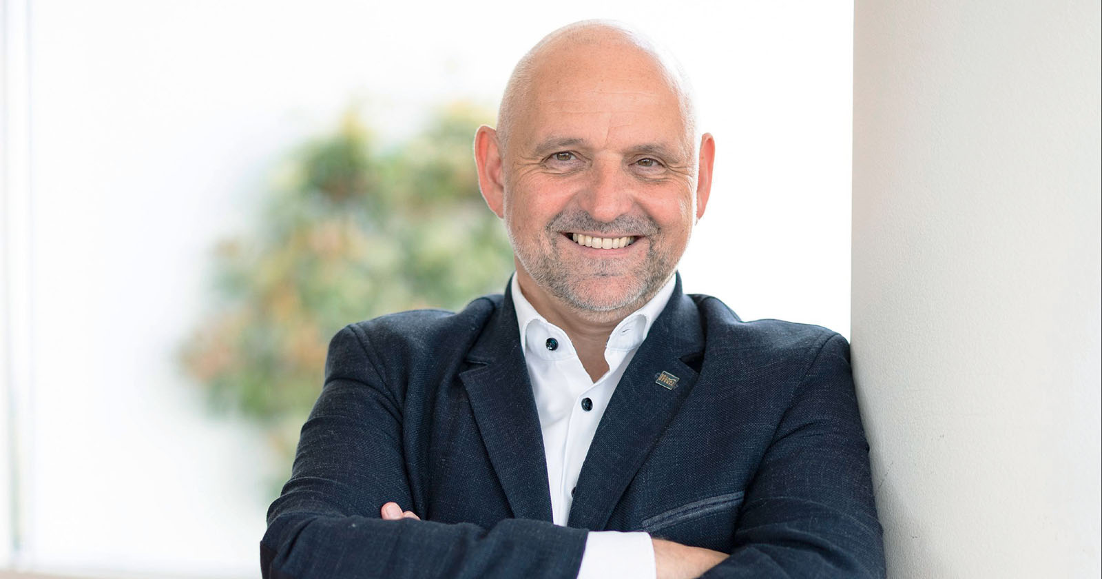 Ein lächelnder Mann mit verschränkten Armen