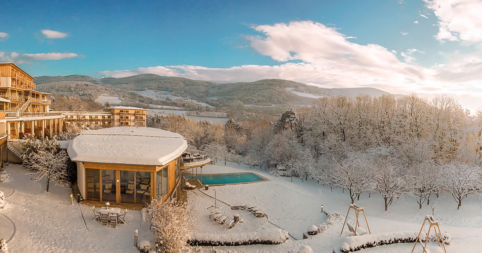 Aussenansicht des Hotels bei Schneelage und blauem Himmel
