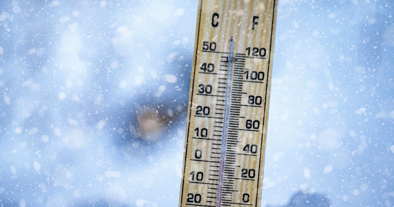 Thermometer, welches umgeben von Eis tiefe Temperaturen anzeigt