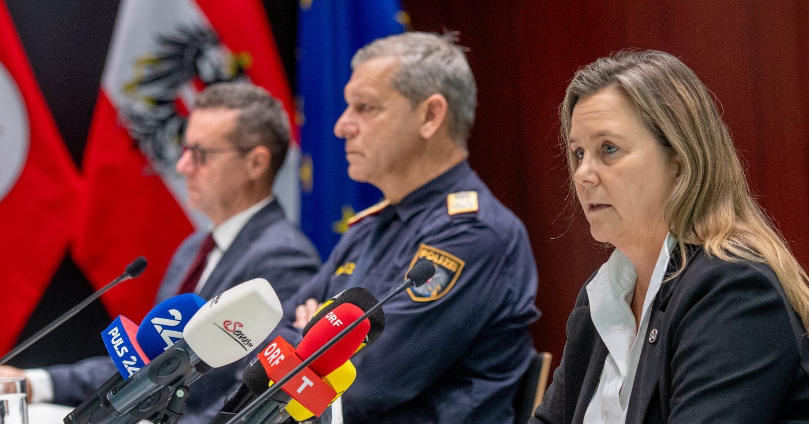 Drei leitende Ermittlungs- und Behördenvertreter sitzen vor Mikrofonen bei einer Pressekonferenz und informieren über den Fund zweier Leichen in einer Innsbrucker Wohnung