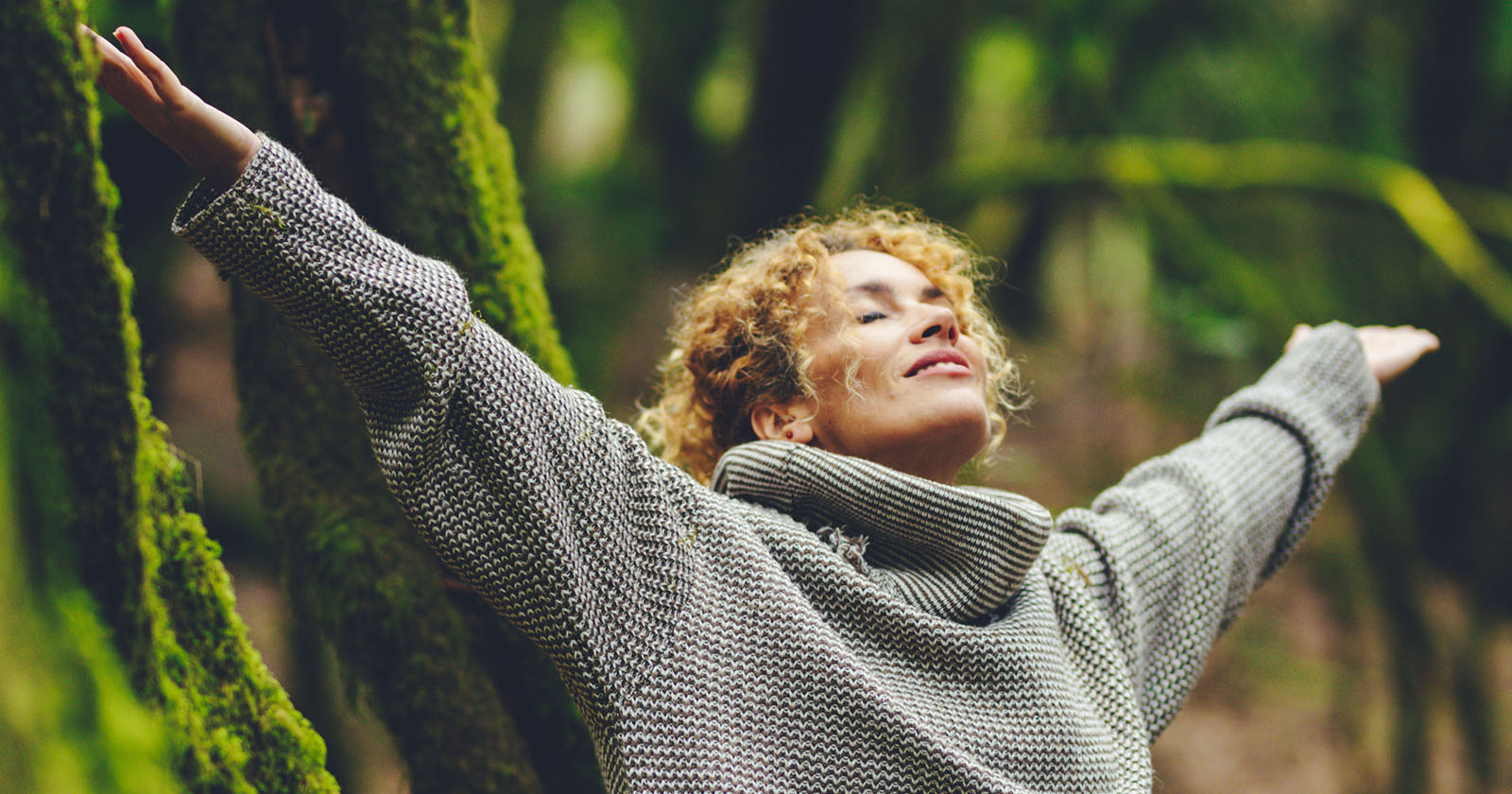 Frau steht mit ausgebreiteten Armen | Credit: iStock.com/simonapilolla