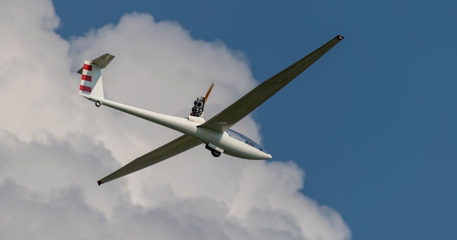 Ein Motorsegelflugzeug in der Luft, ein Motor ist ausgefallen, der Pilot musste auf der Südautobahn notlanden.
