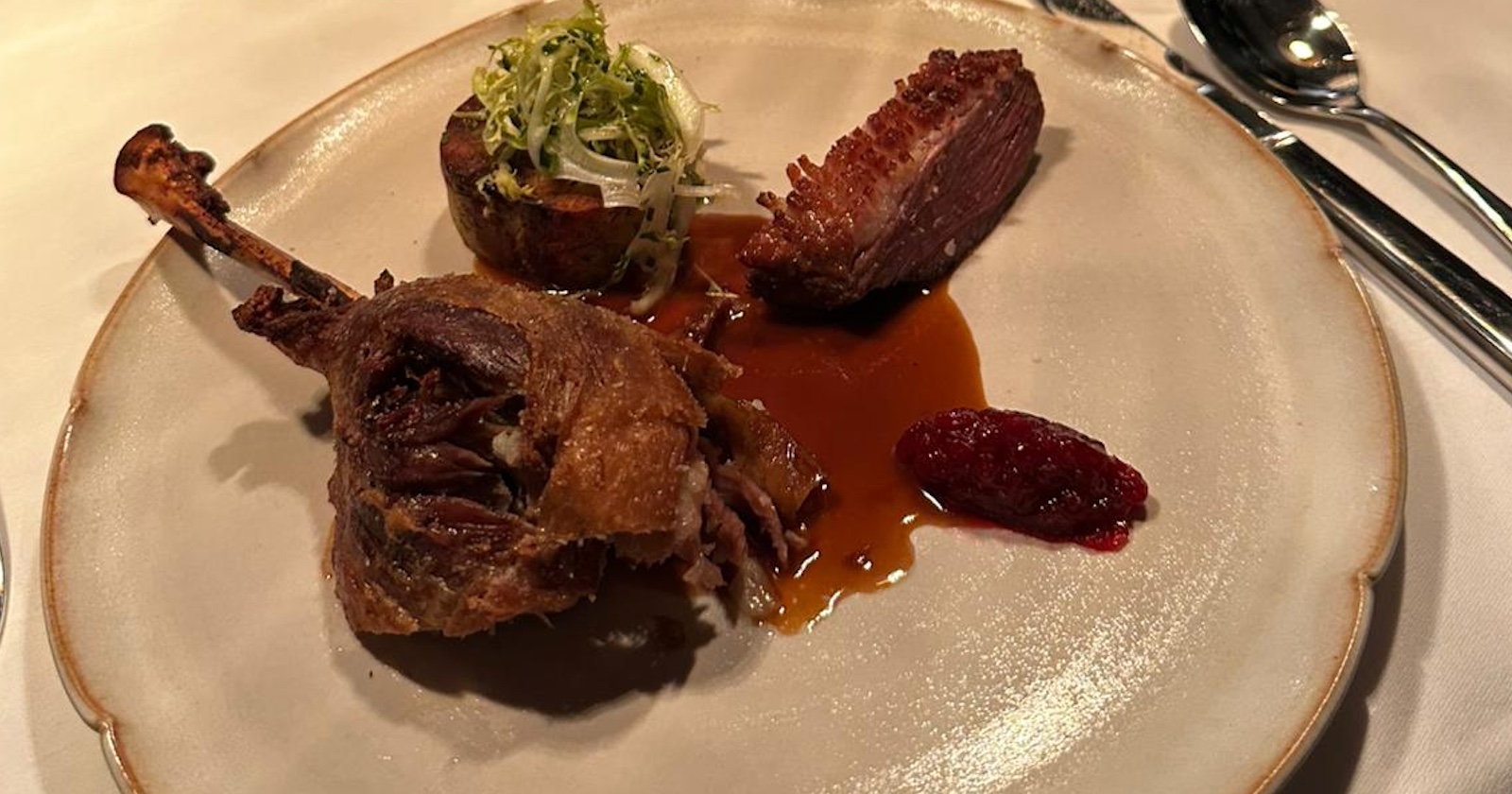 Gänsekeule mit Beilagen auf einem hellgrauen Teller