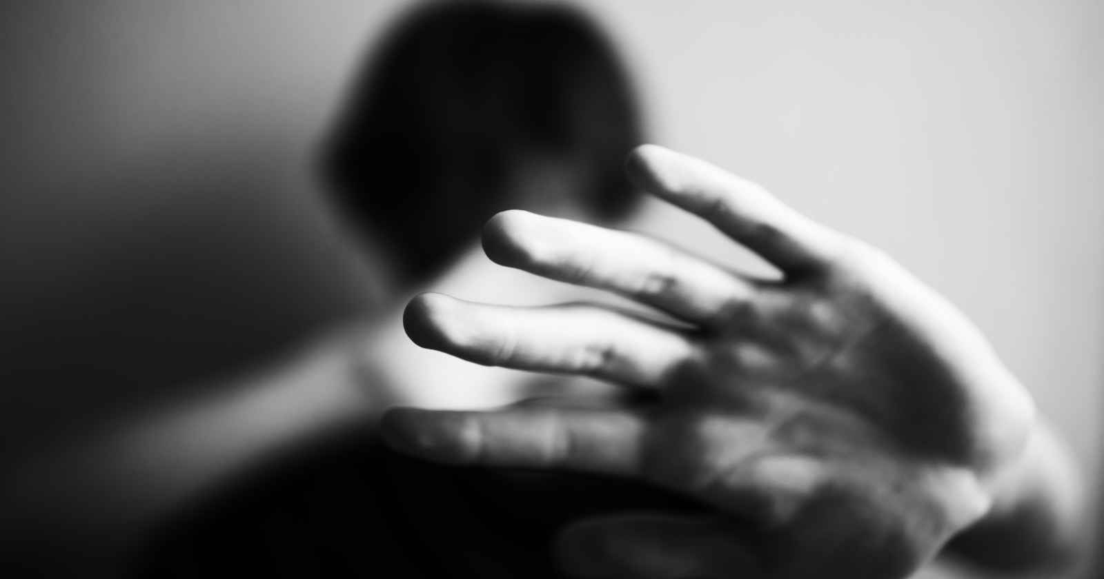 Ein Mann schützt sich sein Gesicht mit der Hand