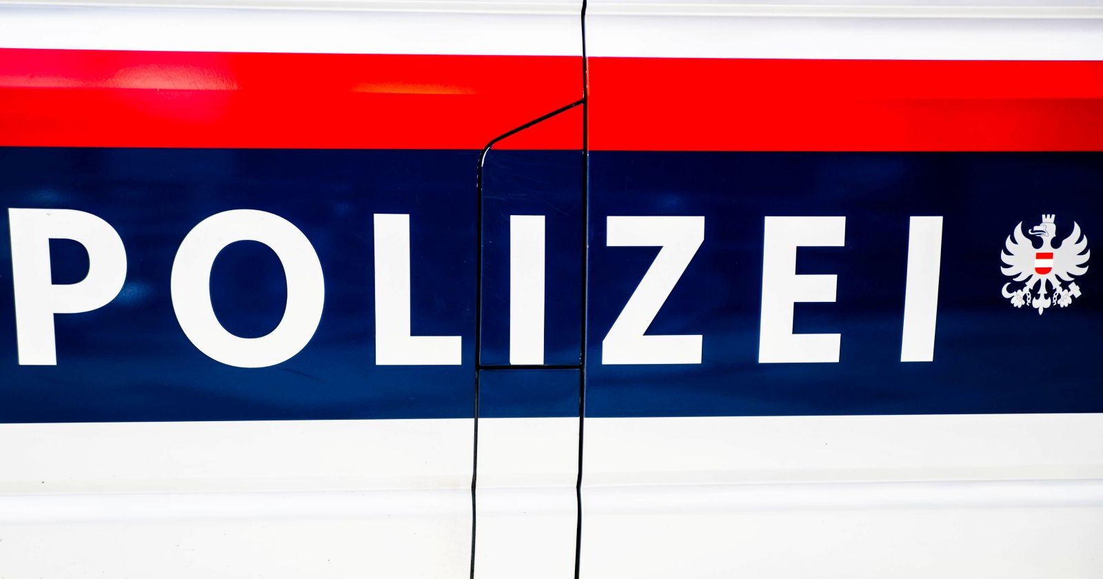 Außenansicht eines Polizeiwagens der österreichischen Polizei in Blau-Rot-silberner Lackierung und dem prägnanten Schriftzug