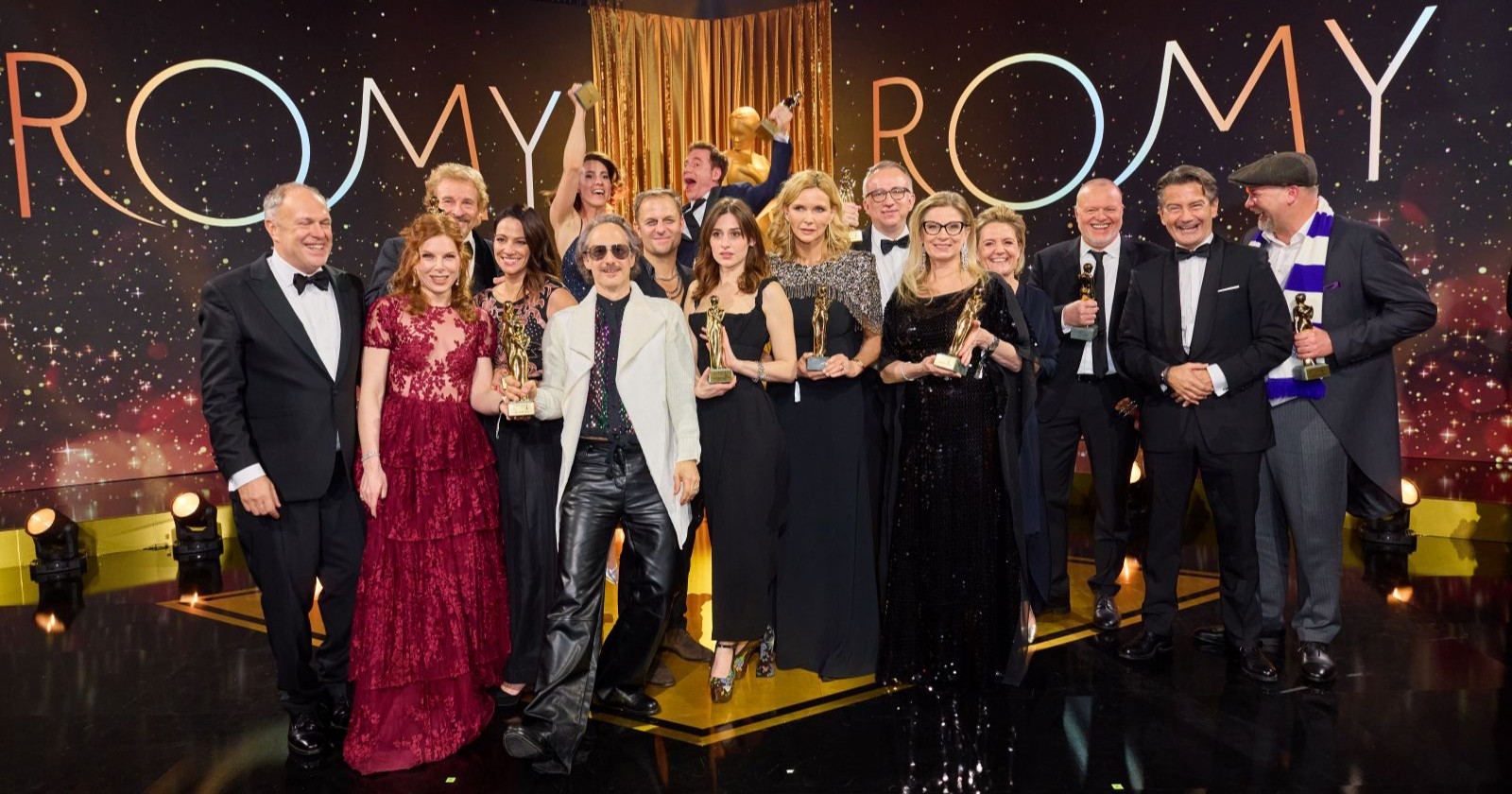 Gruppenfoto der Gewinnerinnen und Gewinner der Kurier Romy 2025 auf der Bühne in Kitzbühel, alle mit ihren Romy-Trophäen in festlicher Abendgarderobe.