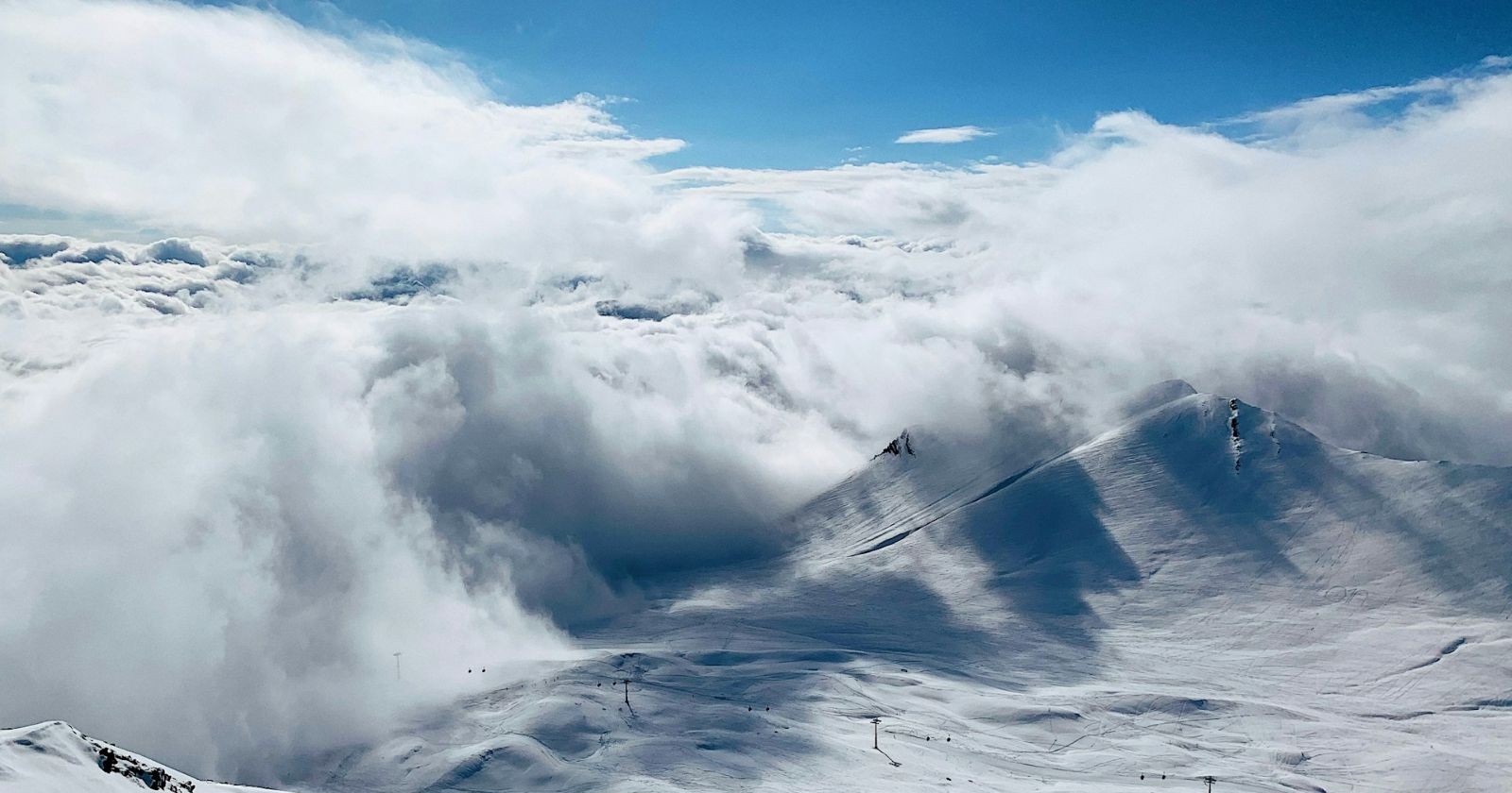 Panorama am Stubaier Gletscher nach Lawinenabgang: Blick auf verschneite Hänge und Wolkenmeer, Einsatz nach Lawine Stubaier Gletscher mit neun Geretteten.