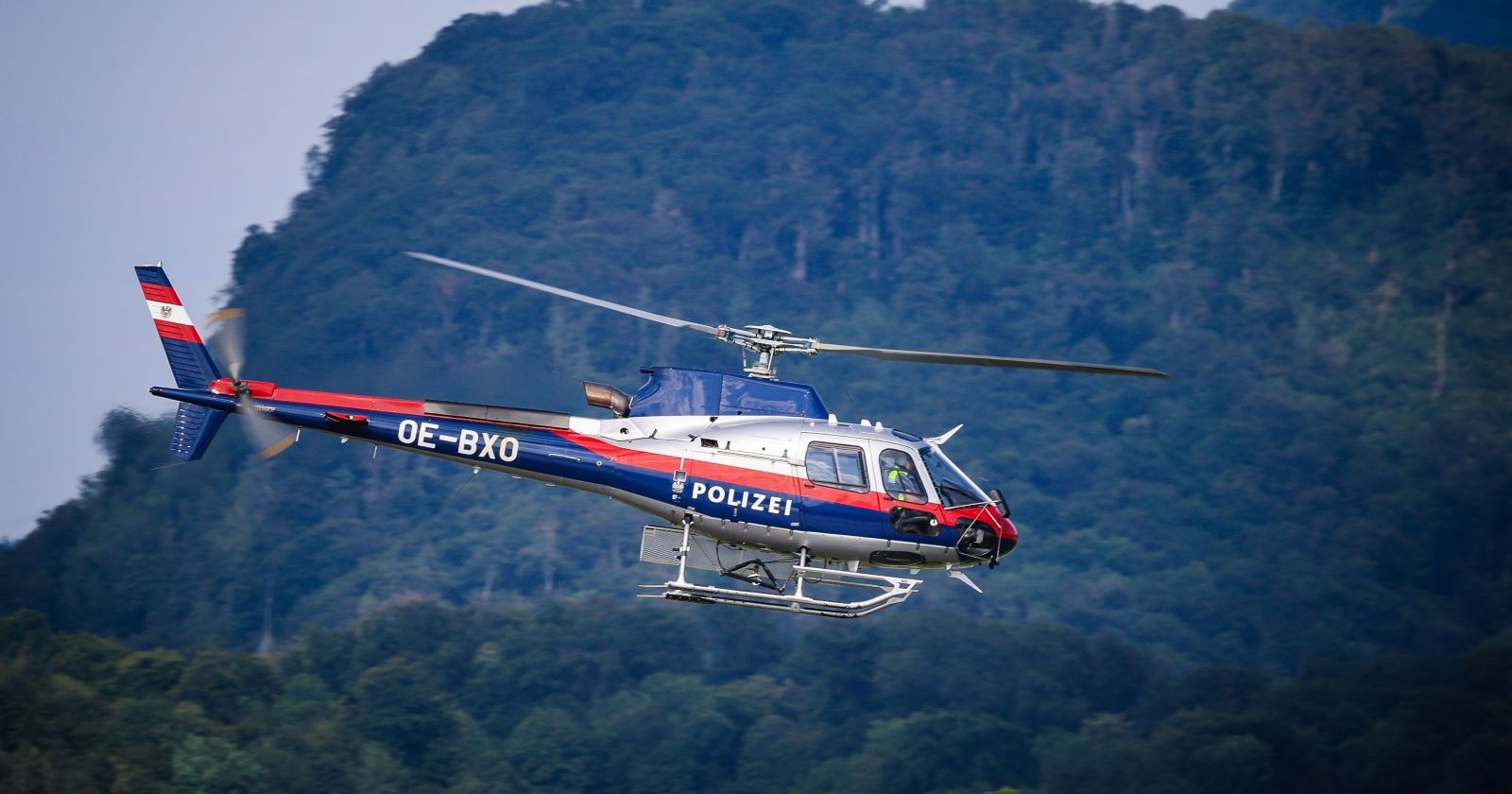 Polizeihubschrauber Libelle im Einsatz vor Bergkulisse