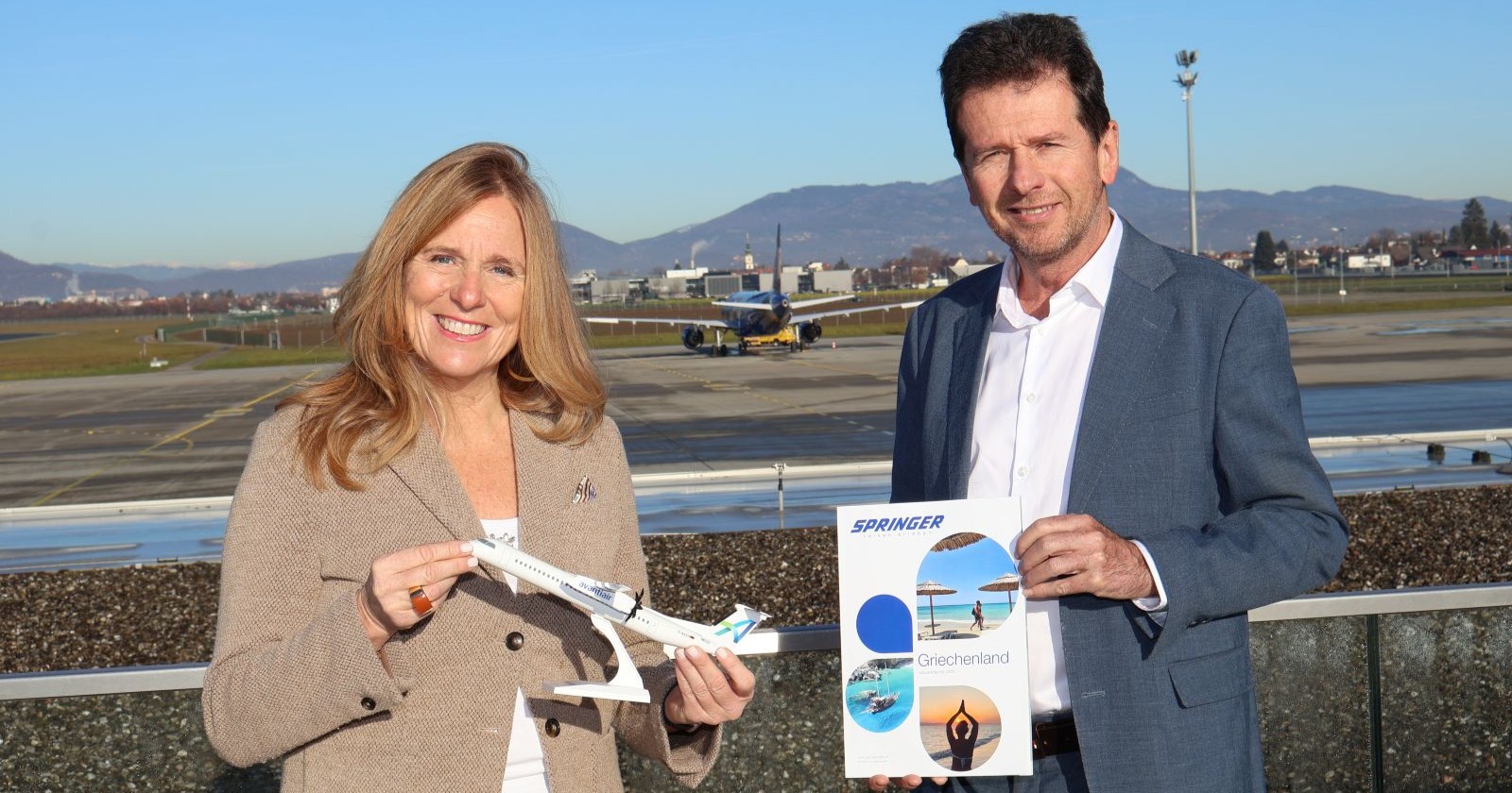 Mann und Frau stehen vor einem Flughafen