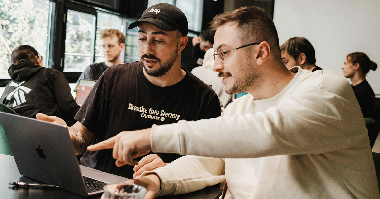 Mann erklärt einem anderen etwas am Notebook | Credit: Forte