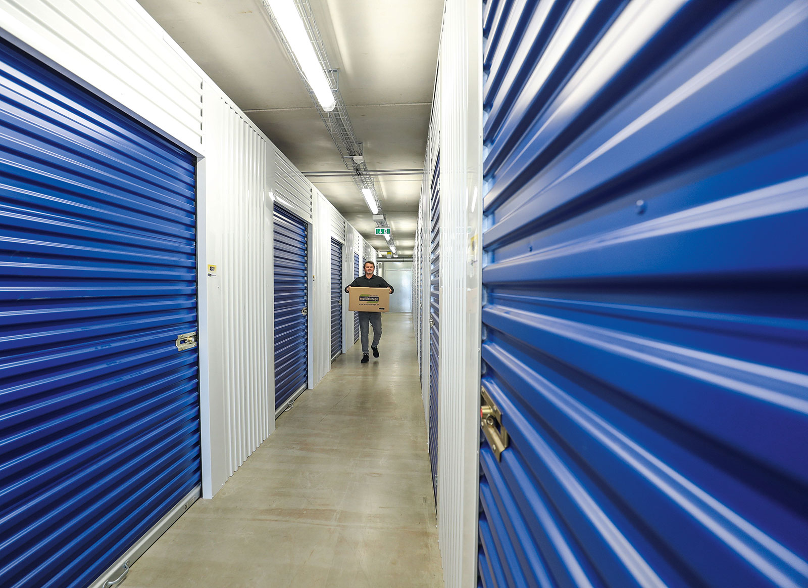 Mann trägt Kartons in Lagerräume | Credit: Multistorage/Franz Neumayr