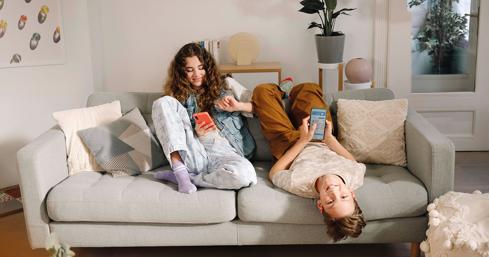 Jugendliche Mädchen auf der Couch mit ihren Smartphones in der Hand | Credit: Raiffeisen