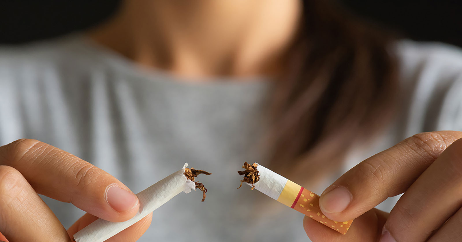 Frau zerbricht Zigarette vor sich | Credit: AdobeStock/Siam Pukkato