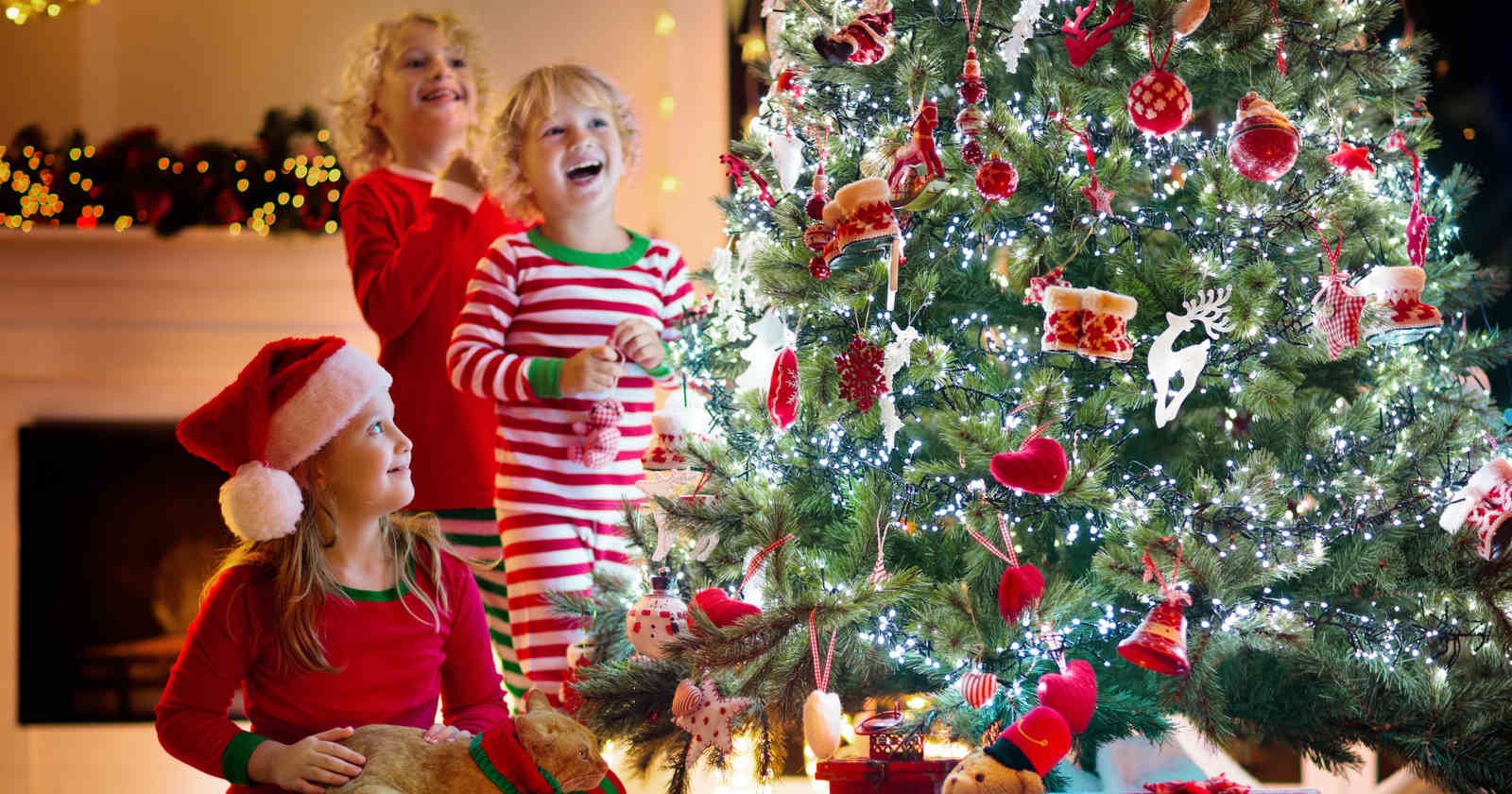 Kinder lachen vor dem Christbaum