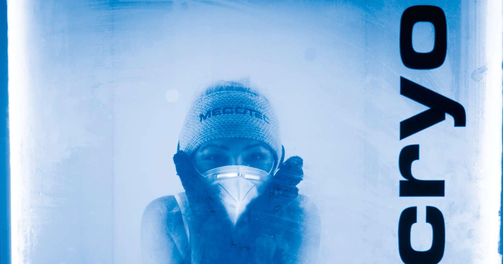 Frau mit Maske und Mütze in einer Kältekammer