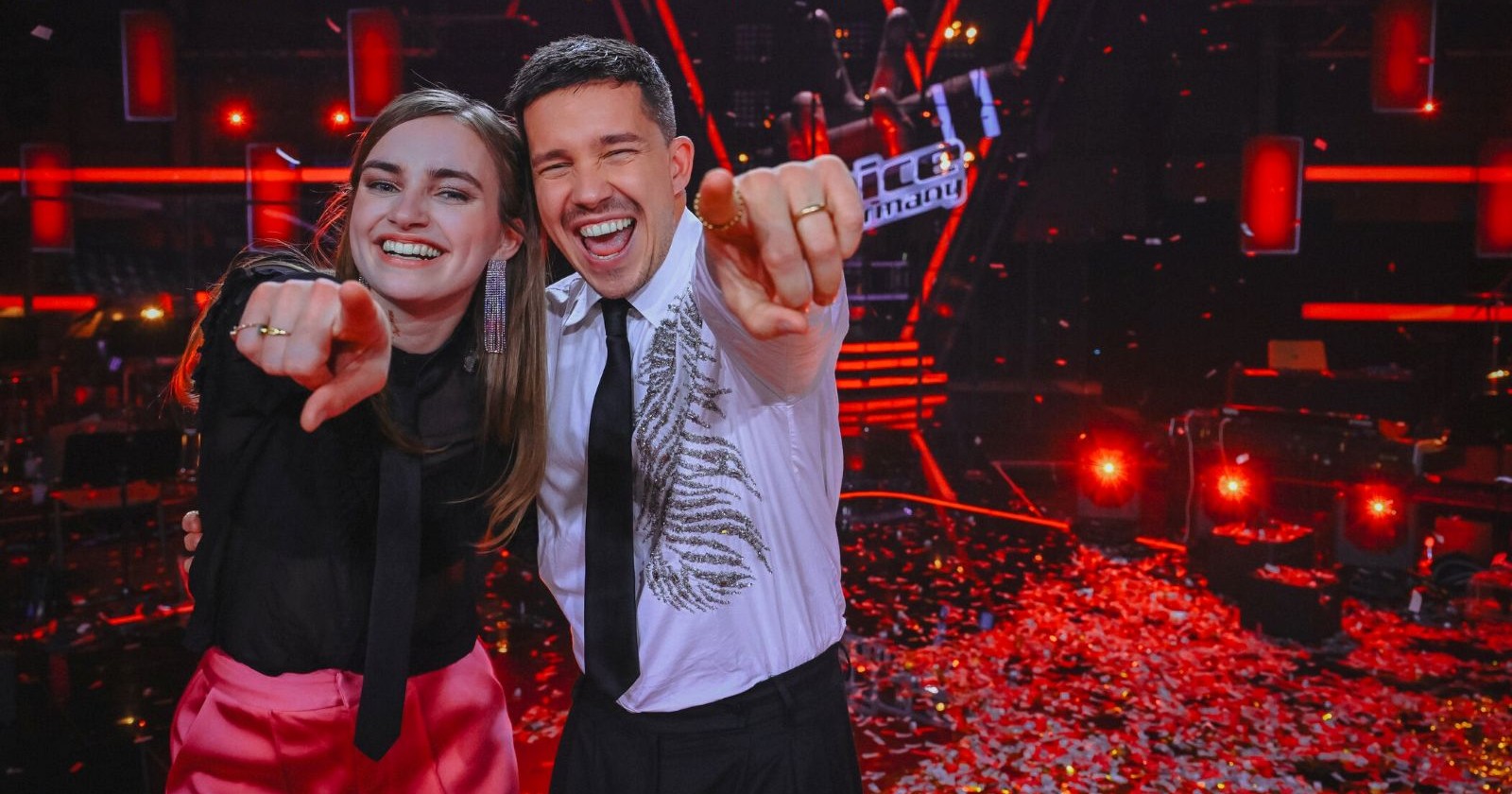 Eine Frau und ein Mann zeigen in die Kamera