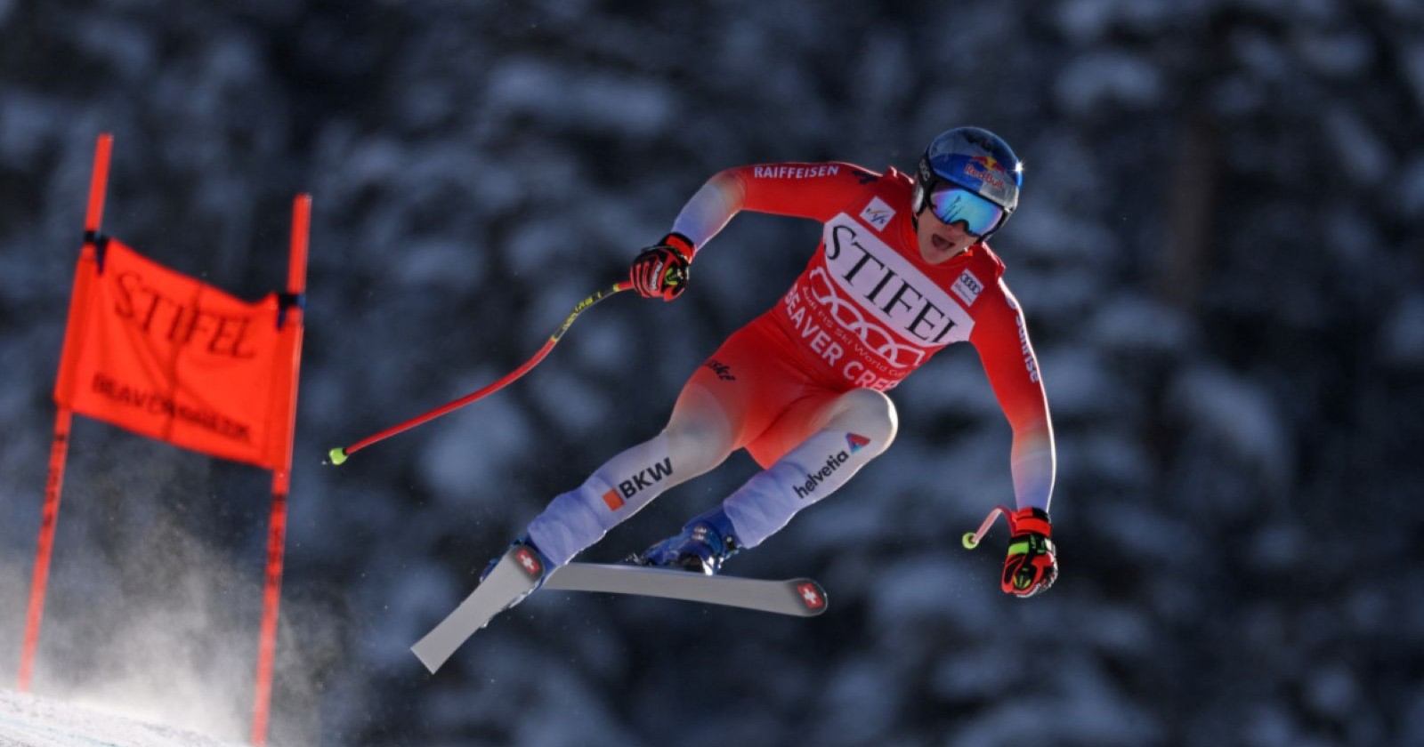 Ein Skifahrer in rotem Rennanzug mit Startnummer „Stifel Beaver Creek“ fliegt in einer Abfahrt über eine Kuppe auf der Weltcupstrecke in Beaver Creek.