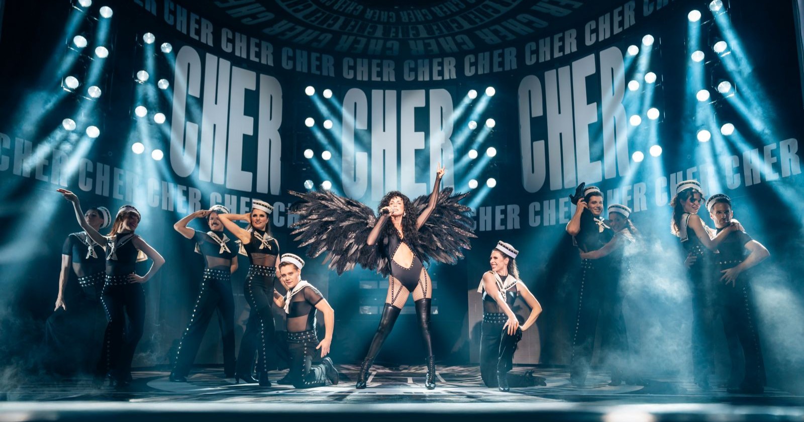 Cher-Darstellerin mit männlichen und weiblichen Tänzern auf der Showbühne