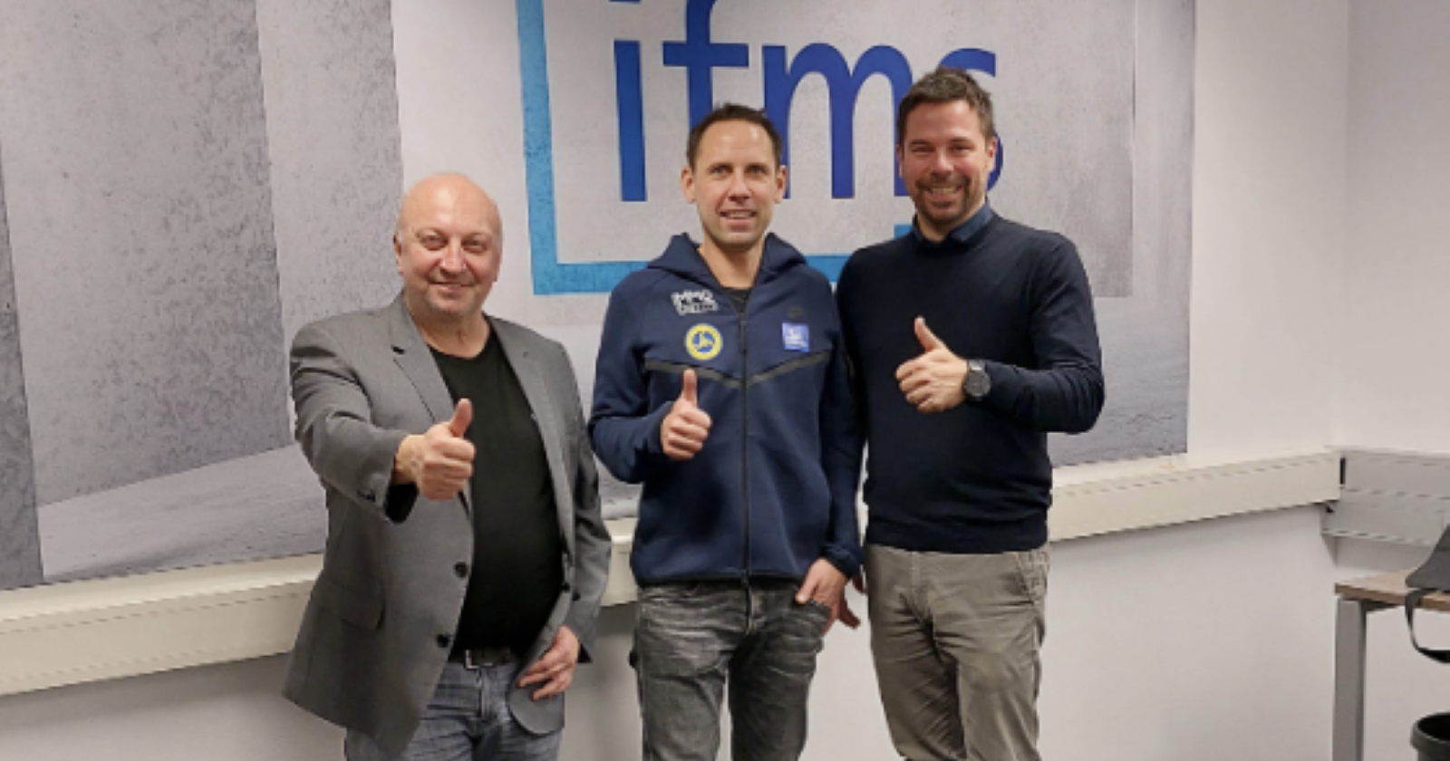 Partner vor dem IFMS- Firmenschild