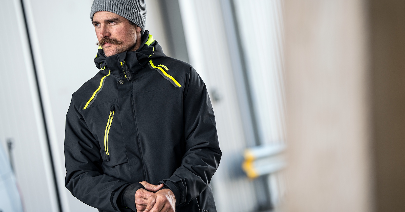 Mann mit dunkelblauer Outdoor-Jacke und grauer Haube